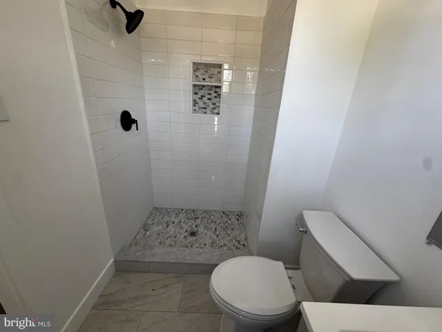 a white toilet sitting next to a shower