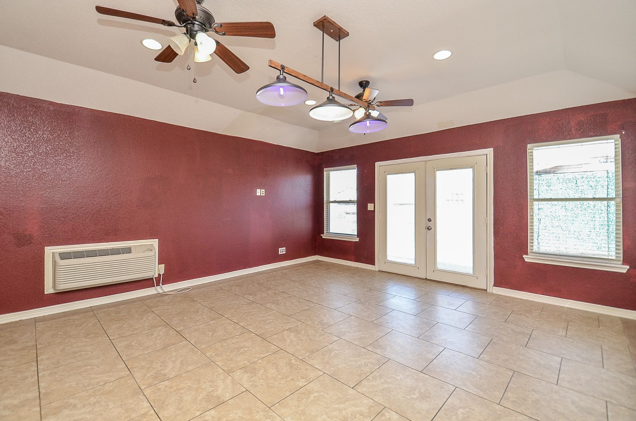 5411 Rio Drive Baytown, TX 77521 - Photo 4 of 30 This main level extra room features tile flooring and burgundy walls accented by ceiling fans and lights. The large windows and glass double doors offer natural light. Its wall mounted air conditioning unit adds comfort and functionality.