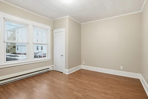 a view of an empty room with wooden floor