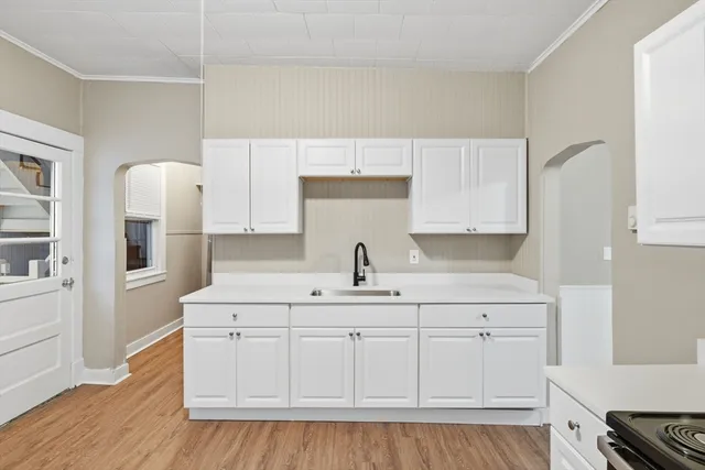 a kitchen with white cabinets and sink