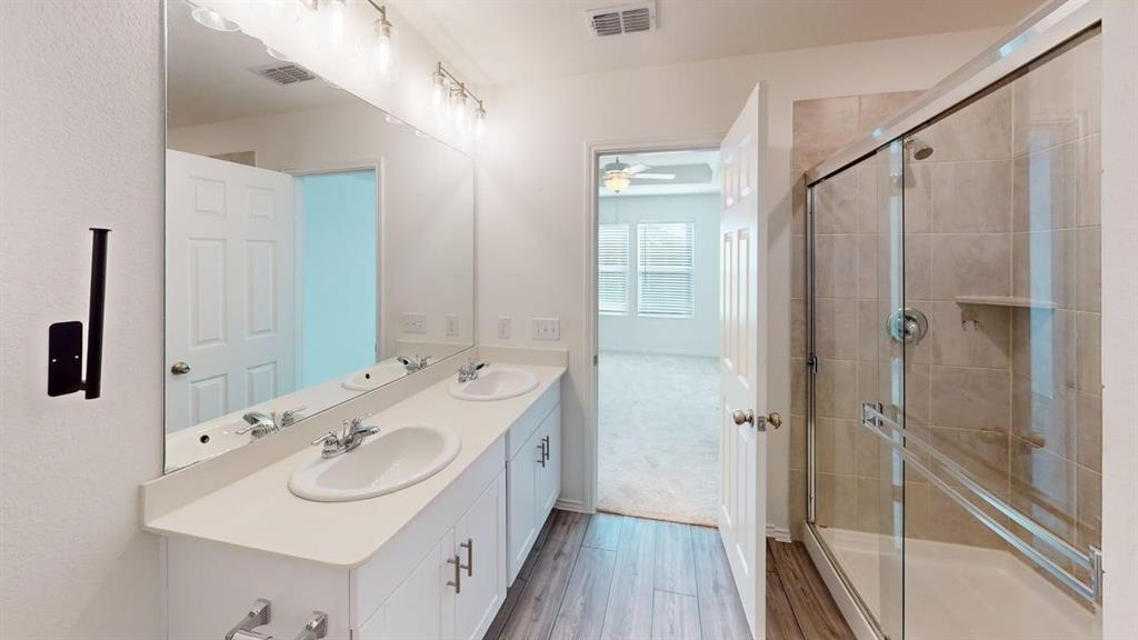 1623 Box Elder Road Forney, TX 75126 - Photo 18 of 22 a bathroom with a sink a mirror a vanity and shower