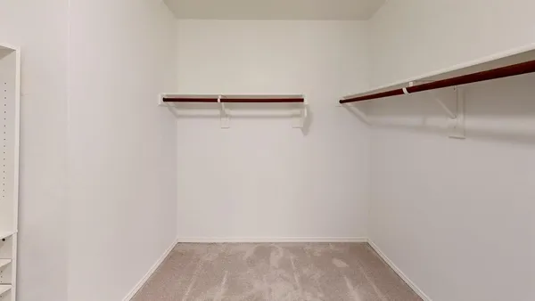 a view of walk in closet with empty racks