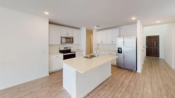 a kitchen with stainless steel appliances a refrigerator and a stove top oven