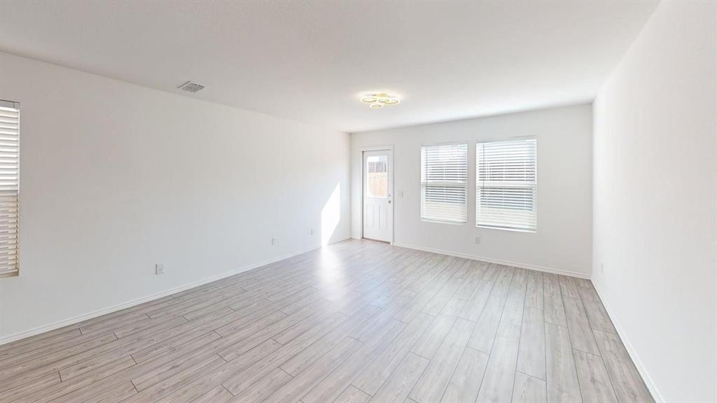 1623 Box Elder Road Forney, TX 75126 - Photo 6 of 22 an empty room with wooden floor and windows