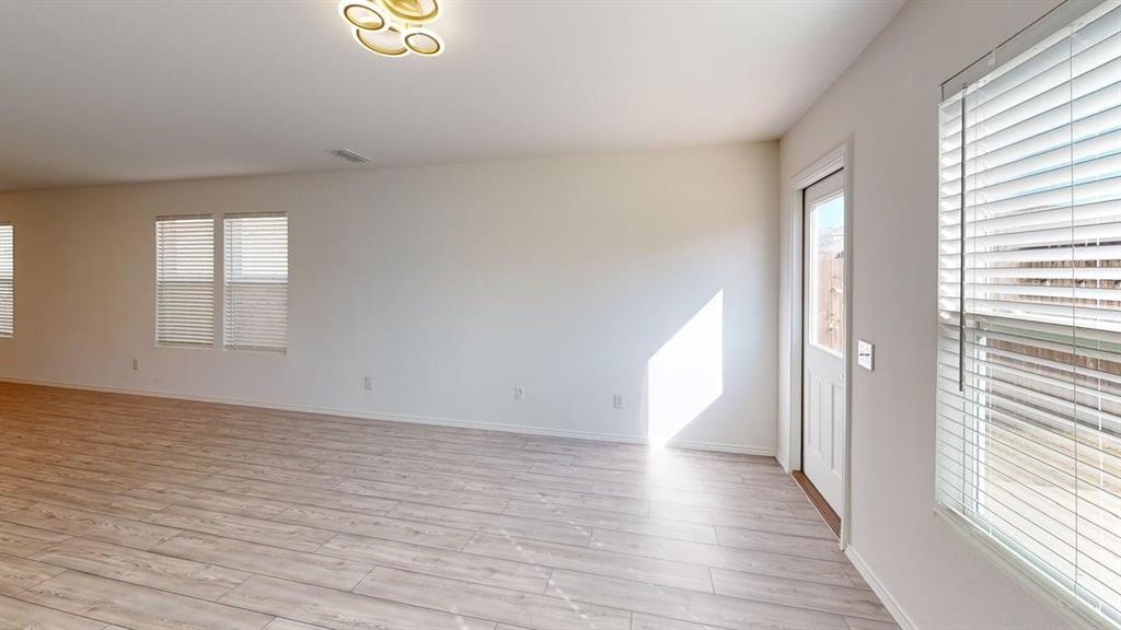 1623 Box Elder Road Forney, TX 75126 - Photo 7 of 22 a view of an empty room with wooden floor and a window