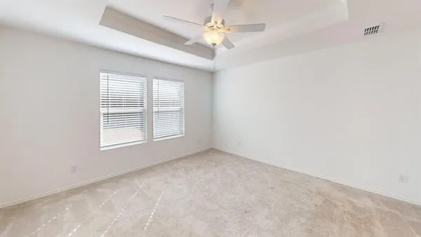 an empty room with a window and a fan