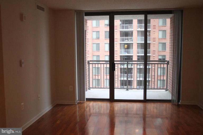 11710 Old Georgetown Road, Unit 824 Rockville, MD 20852 - Photo 2 of 12 a view of an empty room with wooden floor and a window