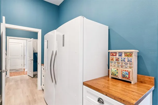 a view of a kitchen with wooden floor and white walls