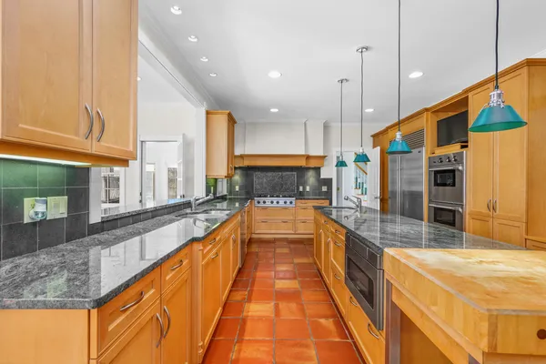 a kitchen with stainless steel appliances granite countertop a stove a sink and a refrigerator