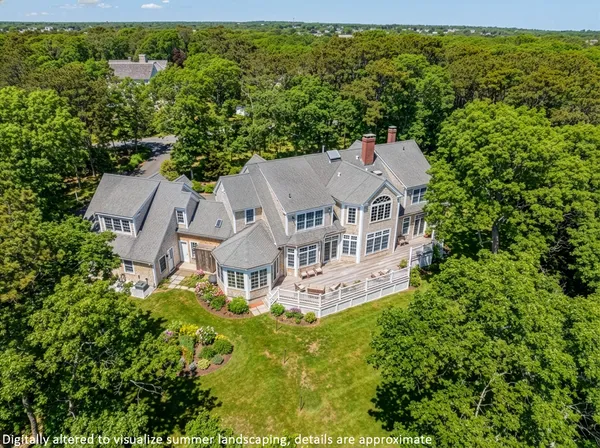 an aerial view of a house with garden space and trees all around
