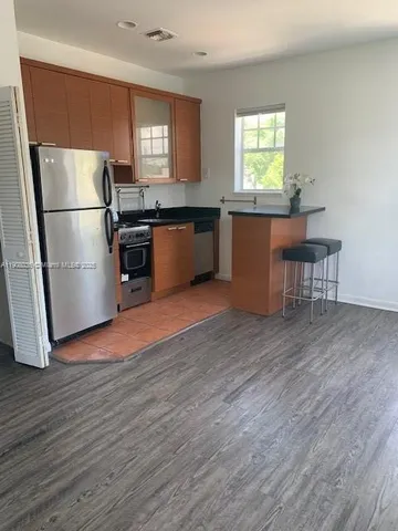 a kitchen with granite countertop a refrigerator and a stove top oven