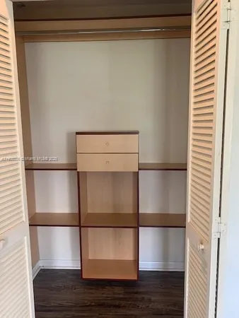 a room with wooden floor and cabinet