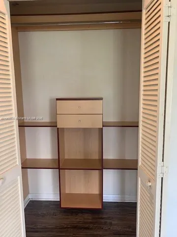 a room with wooden floor and cabinet