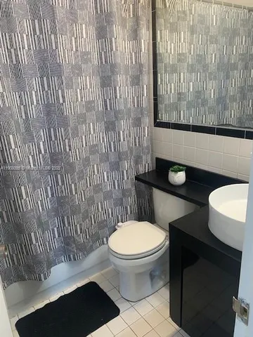 a bathroom with a toilet and a shower curtain