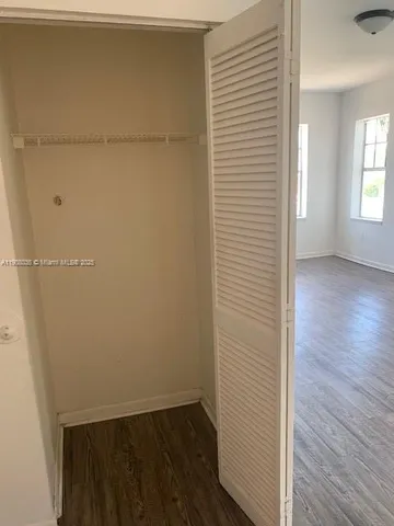 an empty room with wooden floor and closet