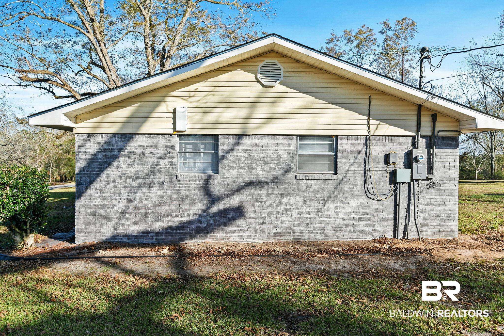 21267 Loop Road Andalusia, AL 36421 - Photo 51 of 72 View of side of home featuring brick siding and a lawn