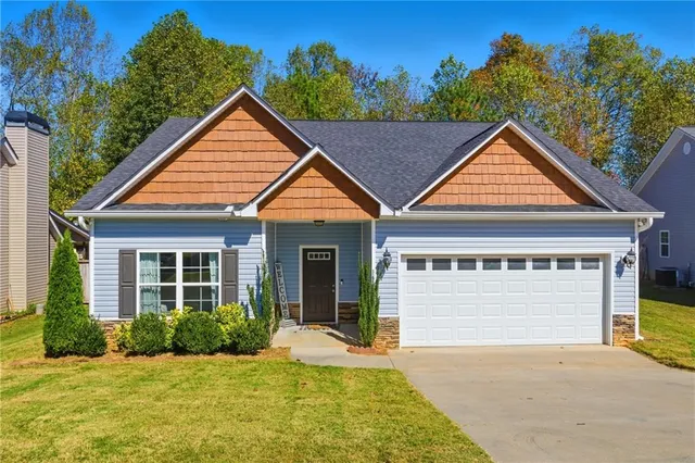 a front view of a house with a yard and garage