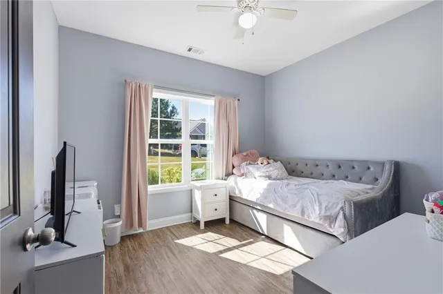 a bedroom with a bed and a flat tv screen on the dresser