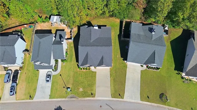 an aerial view of residential houses with outdoor space and trees