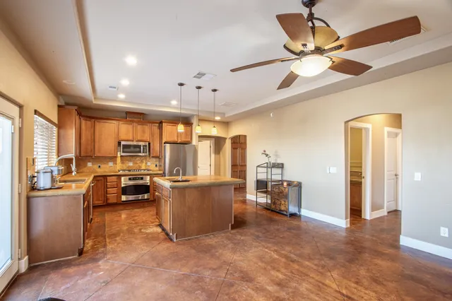 a view of a large kitchen with a sink and refrigerator