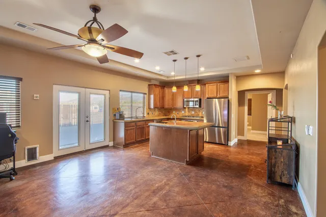 a kitchen with kitchen island a large counter top space appliances and cabinets