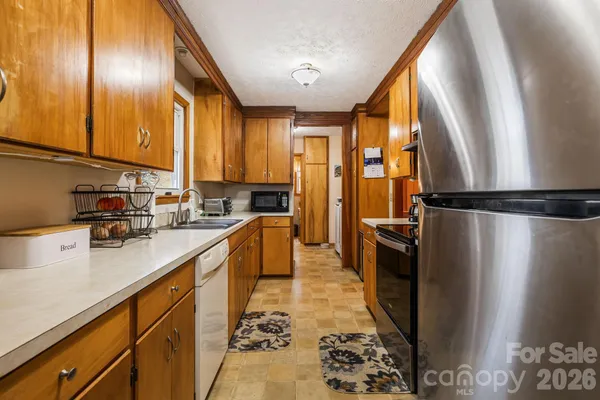 a kitchen with stainless steel appliances granite countertop a refrigerator a sink a stove and blue cabinets