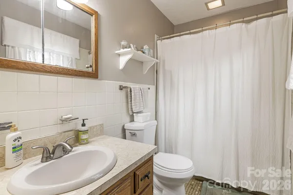a bathroom with a sink a toilet and a mirror