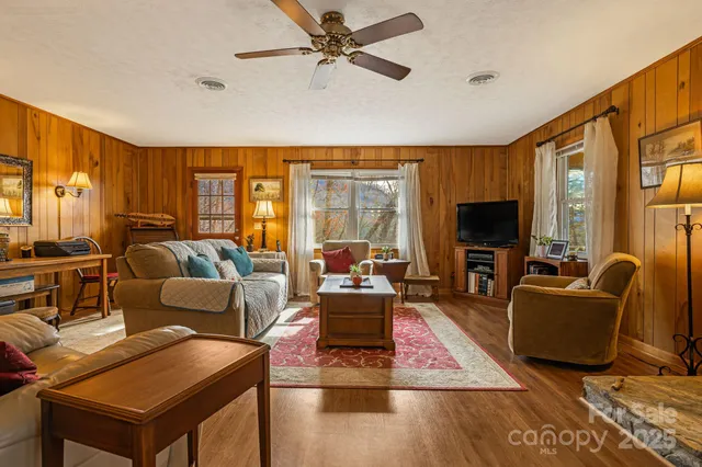 a living room with furniture flat screen tv and a large window