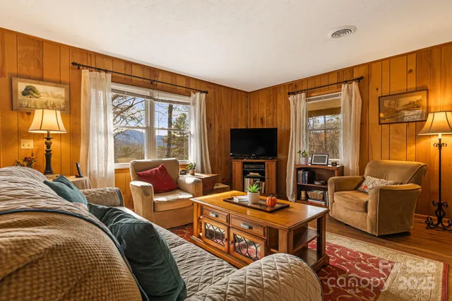 a living room with furniture a large window and a flat screen tv