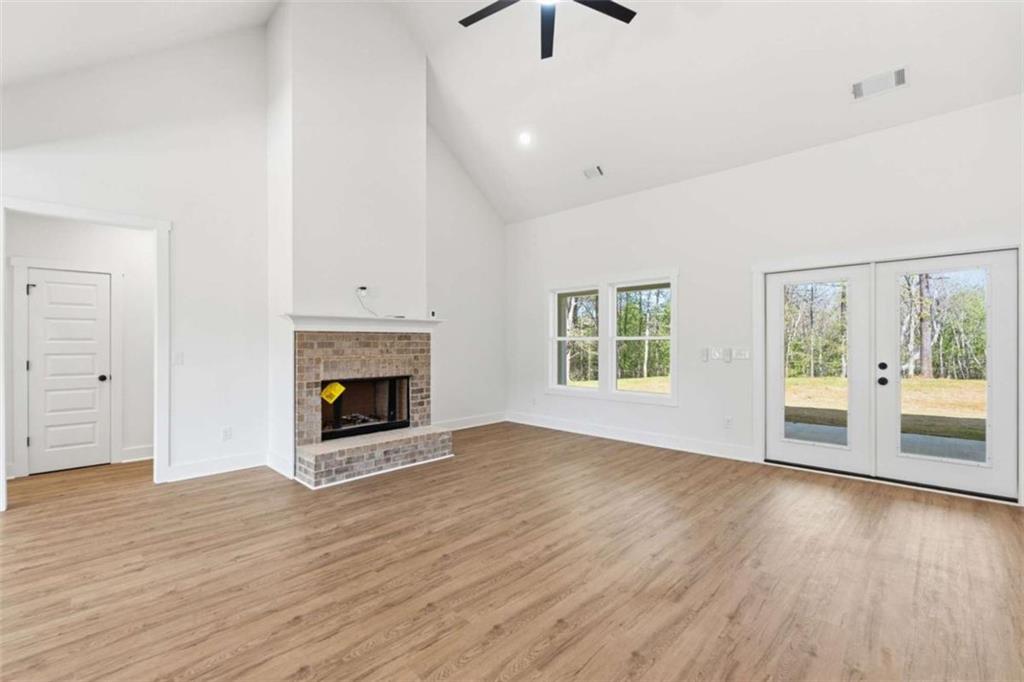 11691 Hazelbrand Road Northeast Covington, GA 30014 - Photo 10 of 53 an empty room with wooden floor a fireplace and windows