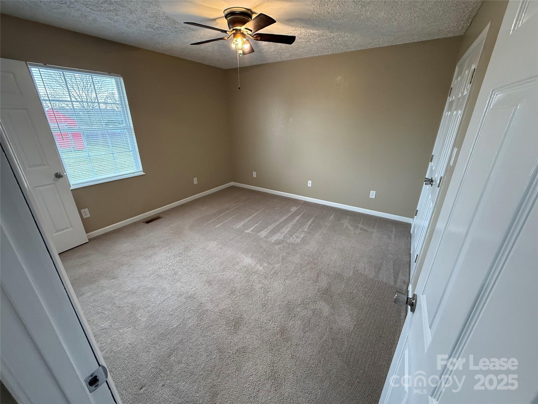 117 Hayworth Lane, Unit 19 Statesville, NC 28625 - Photo 15 of 18 en empty room with windows and fan