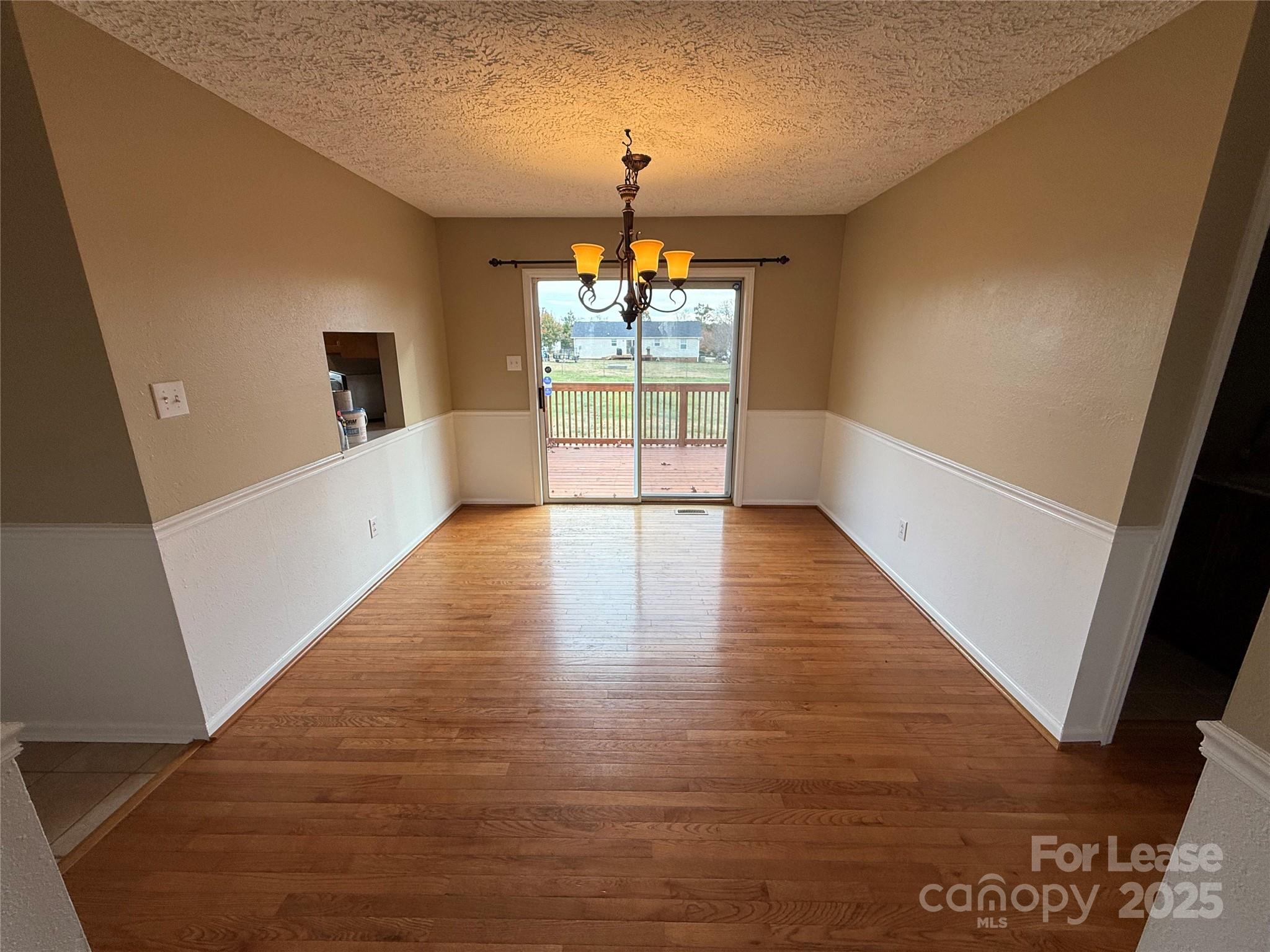 117 Hayworth Lane, Unit 19 Statesville, NC 28625 - Photo 7 of 18 a view of a hallway to an empty room with wooden floor and a window