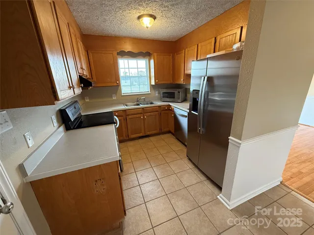 a kitchen with stainless steel appliances a refrigerator sink and microwave