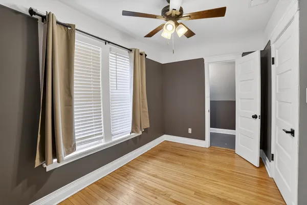 a view of an empty room with window and wooden floor