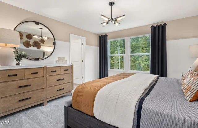 a bedroom with a bed and a lamp on the dresser