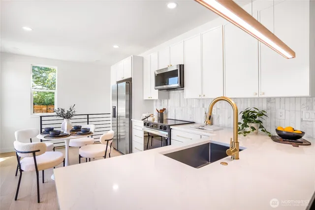 a kitchen with stainless steel appliances a stove a sink a microwave and a refrigerator