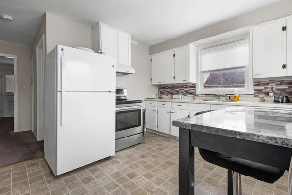 a kitchen with a refrigerator a stove a sink and a counter top space