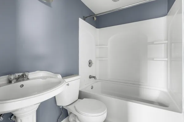 a white toilet sitting next to a bath tub