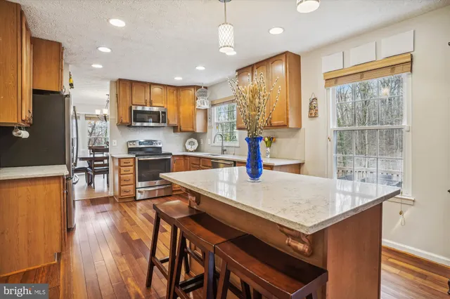 a kitchen with kitchen island a stove a table and chairs in it