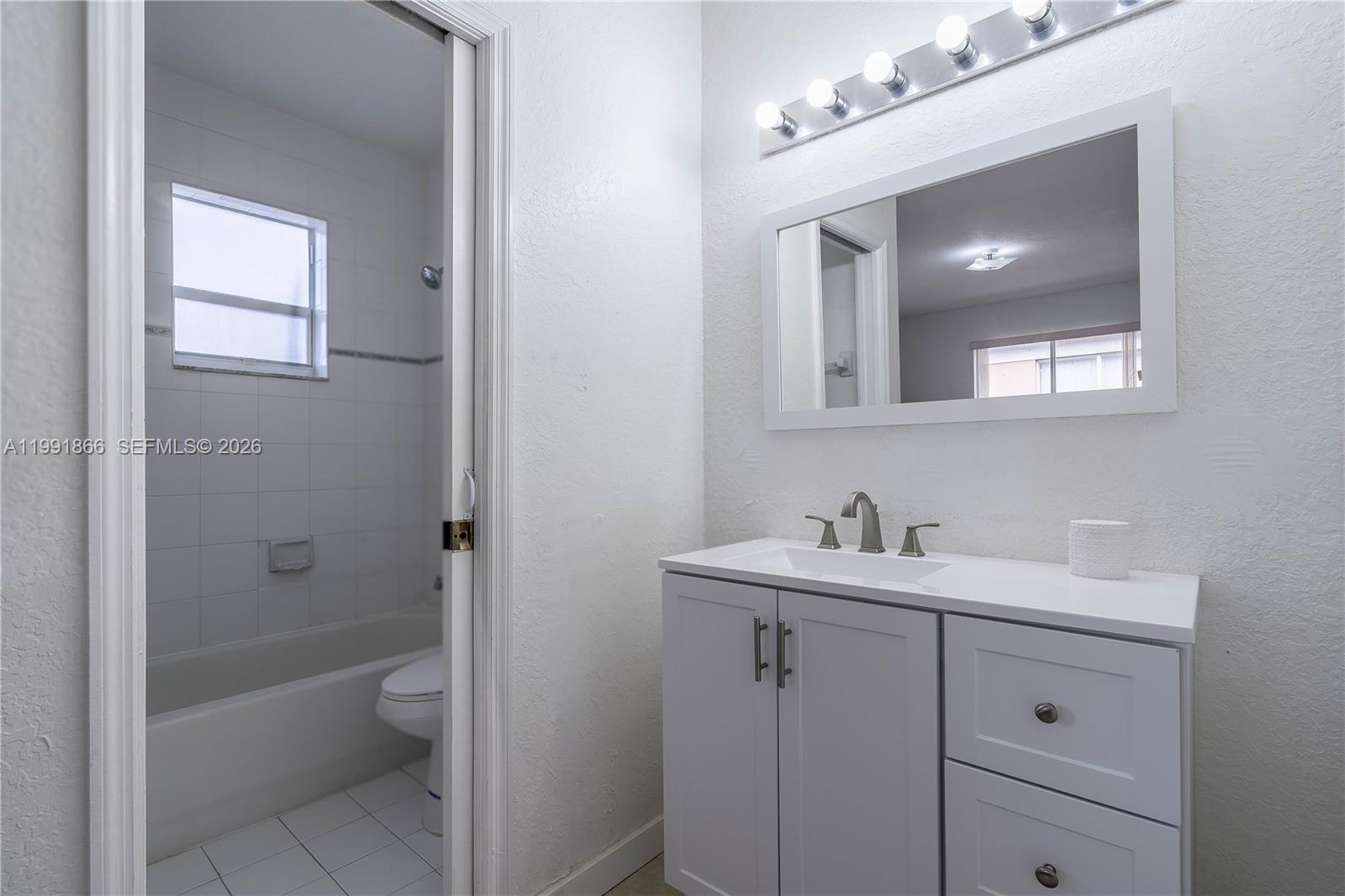 317 East 3rd Street, Unit 201 Hialeah, FL 33010 - Photo 25 of 50 a bathroom with a toilet a sink and mirror