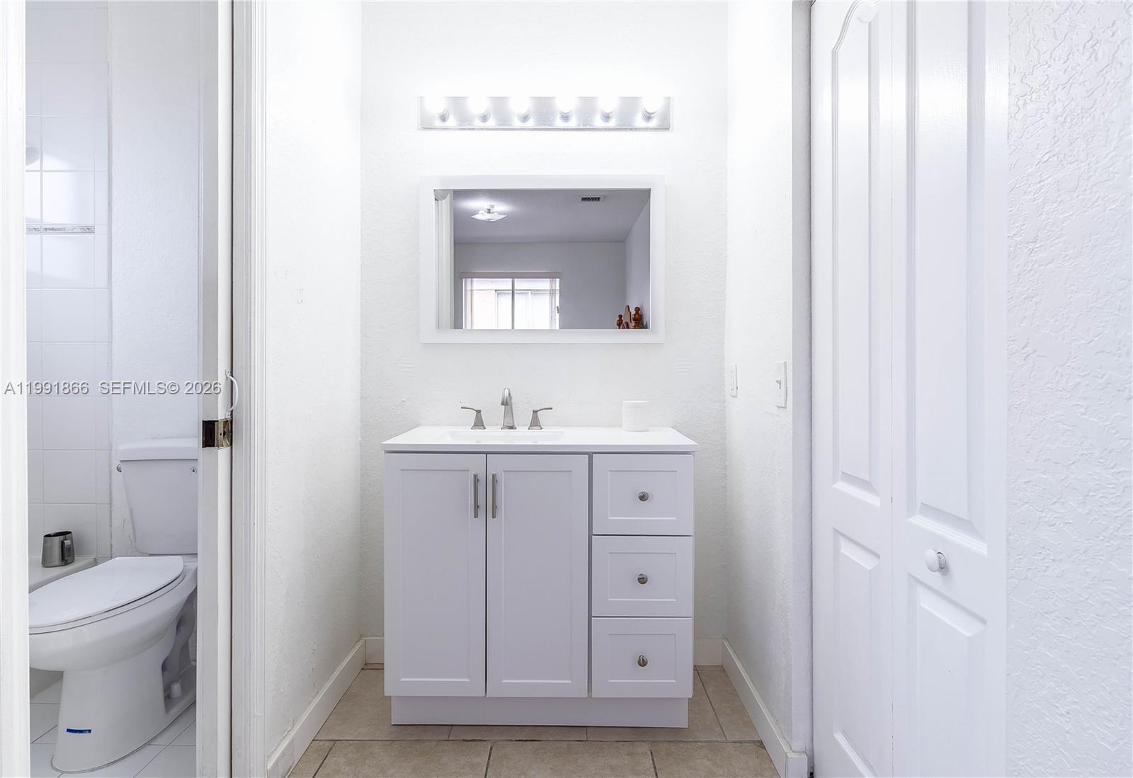 317 East 3rd Street, Unit 201 Hialeah, FL 33010 - Photo 28 of 50 a bathroom with a sink a toilet and a mirror