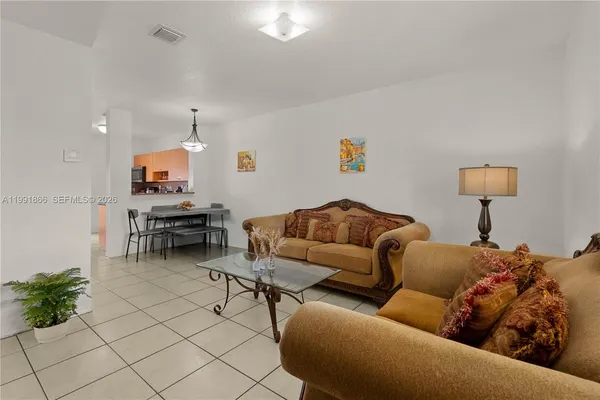 a living room with furniture and a dining table with projector