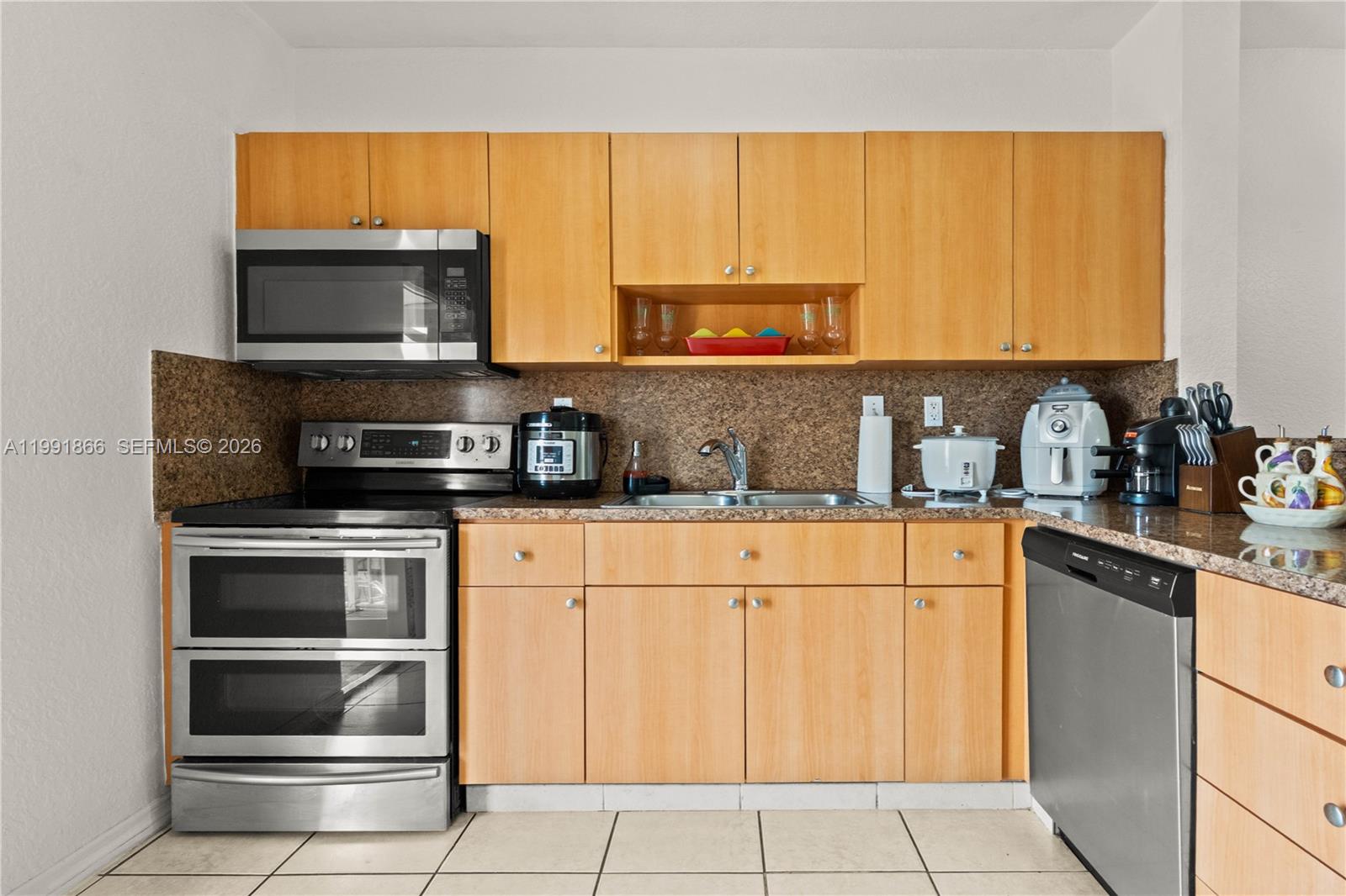 317 East 3rd Street, Unit 201 Hialeah, FL 33010 - Photo 7 of 50 a kitchen with appliances a sink and cabinets