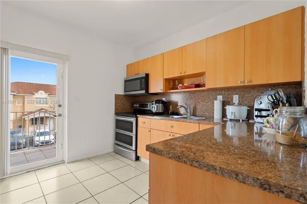a kitchen with a sink a stove and cabinets
