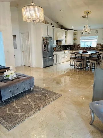 a kitchen with stainless steel appliances kitchen island granite countertop a sink dishwasher a stove and a dining table with wooden floor