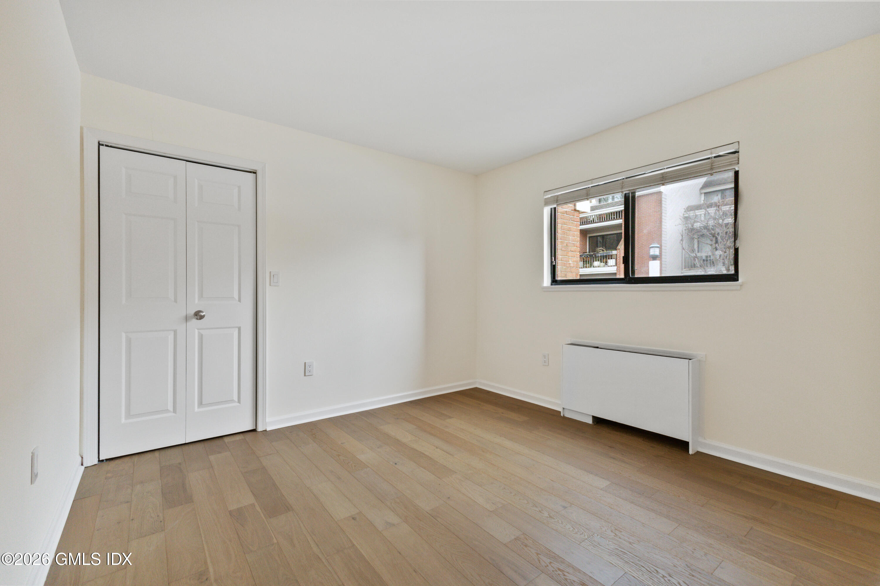 15 River Road, Unit 210 Cos Cob, CT 06807 - Photo 12 of 23 a view of an empty room with wooden floor and closet