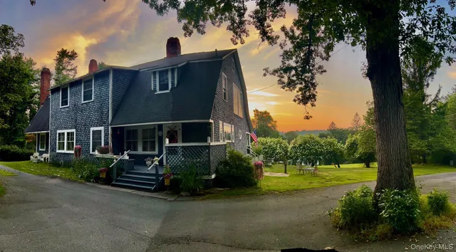 a view of a house with backyard and a tree