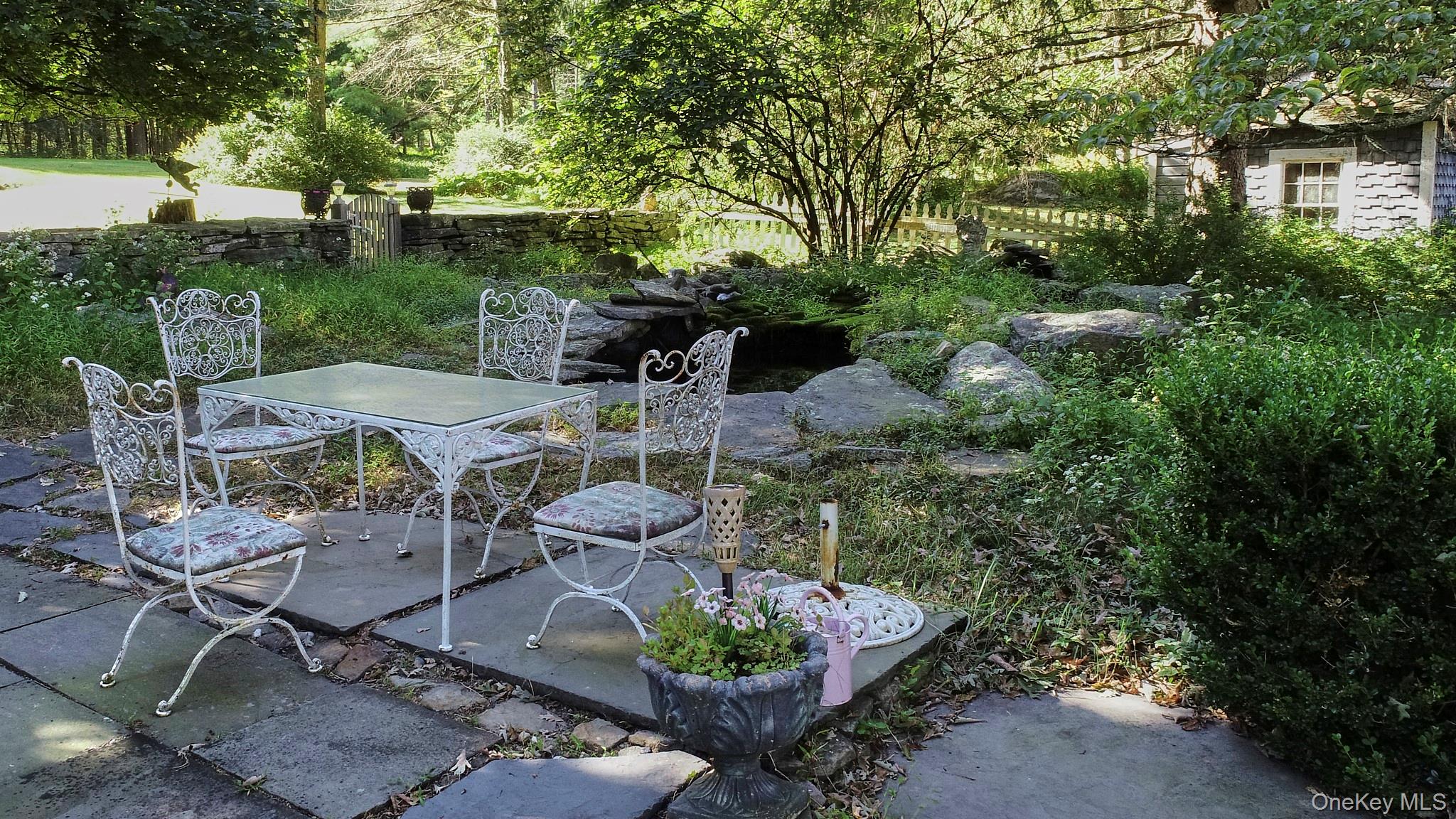 22 Proctor Road Eldred, NY 12732 - Photo 48 of 50 a view of a backyard with table and chairs potted plants and large tree