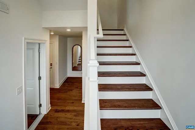 a kitchen with stainless steel appliances kitchen island granite countertop a stove a sink a dining table and chairs with wooden floor