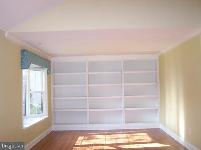 a view of a room with wooden floor and windows